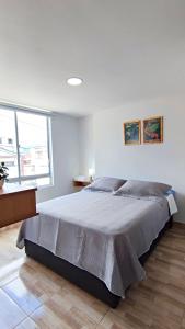 ein Schlafzimmer mit einem großen Bett in einem weißen Zimmer in der Unterkunft Villa Quintero apartamentos in Santa Rosa de Cabal