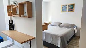 a small bedroom with a bed and a table at Villa Quintero apartamentos in Santa Rosa de Cabal +3 photos
