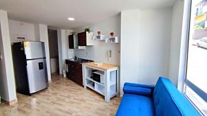 cocina con sofá azul y nevera en Villa Quintero apartamentos, en Santa Rosa de Cabal