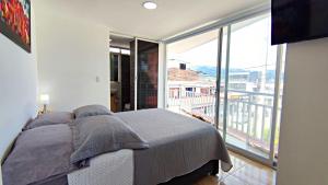 a bedroom with a bed and a large window at Villa Quintero apartamentos in Santa Rosa de Cabal
