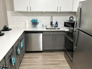 a kitchen with white cabinets and a stainless steel refrigerator at Modern Vibes 1br/1ba Oak Park IL in Oak Park