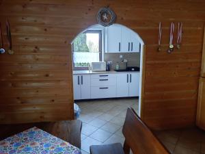 a kitchen with white cabinets and a window at Pokoje u Juroszka in Istebna