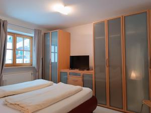 a bedroom with two beds and a desk with a television at Wikasa in Ofterschwang