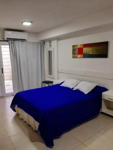 a bedroom with a blue bed in a room at Hermoso departamento céntrico! in San Miguel de Tucumán