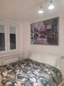 een slaapkamer met een bed met een foto aan de muur bij SilverSky Duo in Warschau