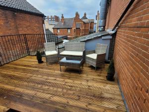 a deck with chairs and tables on a building at Wallgate House Apartments- Step back into Roman history with Catchpole Stays in Colchester