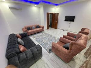 ダカールにあるAPPARTEMENTS DE REVE A ALMADIES DAKARのソファ2脚と薄型テレビのあるリビングルーム