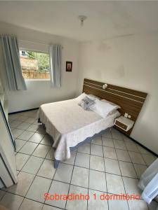 a bedroom with a bed and a window at Parada dos Golfinhos in Florianópolis
