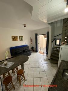 a kitchen and living room with a table and chairs at Parada dos Golfinhos in Florianópolis