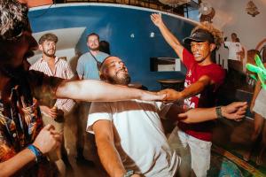 um grupo de homens dançando em uma festa em Viajero San Andres Hostel em San Andrés