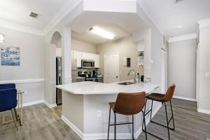 a kitchen with a large white counter and chairs at Orlando Retreat 2B2B / Disney-Universal-SeaWorld in Orlando