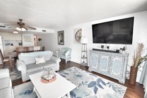 sala de estar con TV de pantalla plana grande en 0602 Waters Edge Resort condo, en Myrtle Beach