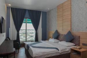 a bedroom with a bed and a large window at Asenappar Hotel in Erbil
