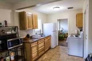 cocina con armarios de madera y nevera blanca en The Stardust Cottage Near Downtown Klamath Falls, en Klamath Falls