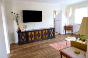 a living room with a flat screen tv on a wall at The Stardust Cottage Near Downtown Klamath Falls in Klamath Falls