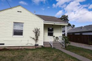 a white house with a fence in front of it at The Stardust Cottage Near Downtown Klamath Falls in Klamath Falls
