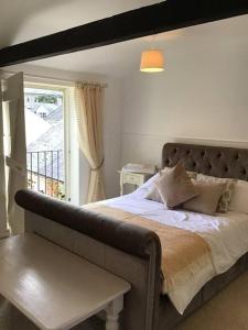 a bedroom with a large bed and a window at The Coach House at Pitchards in Halstead