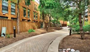 a brick walkway in front of a building with trees at Modern Vibes 1br/1ba Oak Park IL in Oak Park