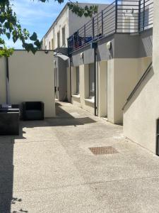 an empty sidewalk next to a building with a balcony at Jolie perle in Saint-Priest