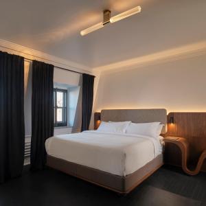 a bedroom with a large white bed and a window at Hotel Cap Diamant in Quebec City