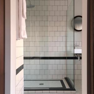 baño con ducha y puerta de cristal en Hotel Cap Diamant en Quebec