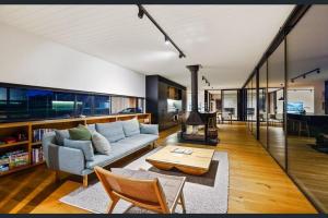 a living room with a couch and a table at Spectacular Kangaroobie Cabin in Borenore