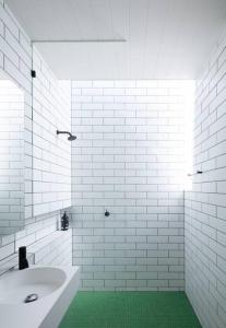 a white bathroom with a sink and a green floor at Spectacular Kangaroobie Cabin in Borenore