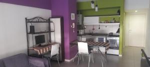 cocina con paredes moradas y verdes, mesa y sillas en Donato anhelo departamento en caballito norte en Buenos Aires