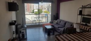 sala de estar con sofá y ventana grande en Donato anhelo departamento en caballito norte en Buenos Aires