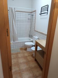 a bathroom with a toilet and a tub and a sink at Apartamento rural Dúplex del monte in Cazalla de la Sierra