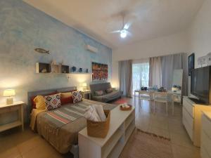 a bedroom with a bed and a living room at Apartamento Cadaques caribe Bayahibe in Bayahibe