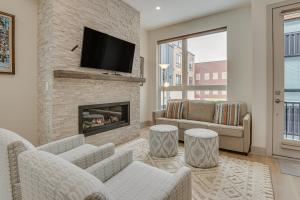 a living room with a fireplace and a tv at Silverthorne Townhome with Hot Tub Walk to Town! in Silverthorne