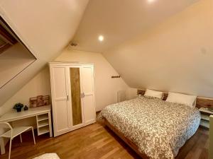 a attic bedroom with a bed and a cabinet at Maison near Disneyland , Paris in Champs-Sur-Marne