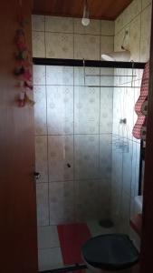 a bathroom with a toilet and a tiled wall at Sonho na Serra Chalé 1 in Gonçalves