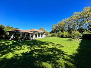 una casa en un campo con un gran patio en Ecrin de verdure Entre forêt et océan en Saint-Martin-de-Seignanx