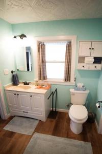 La salle de bains est pourvue de toilettes blanches et d'un lavabo. dans l'établissement Cozy Comfort Minutes From Downtown Klamath Falls, à Klamath Falls