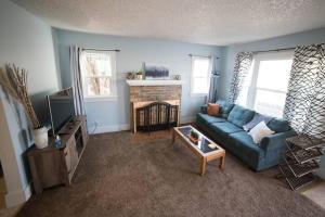 a living room with a blue couch and a fireplace at Cozy Comfort Minutes From Downtown Klamath Falls in Klamath Falls