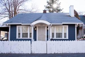 a blue house with a white fence at Cozy Comfort Minutes From Downtown Klamath Falls in Klamath Falls