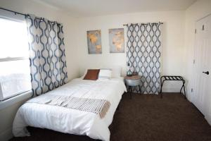 - une chambre avec un grand lit blanc et une fenêtre dans l'établissement Cozy Comfort Minutes From Downtown Klamath Falls, à Klamath Falls