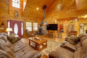 a living room with a couch and a television in a cabin at Riverfront Luther Cottage with Year-Round Trail! in Luther