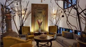 Riad Soir De Marrakech في مراكش: غرفة معيشة مع أريكة وكراسي وطاولة