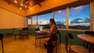 a woman sitting at a table in a bar at Viajero San Andres Hostel in San Andrés