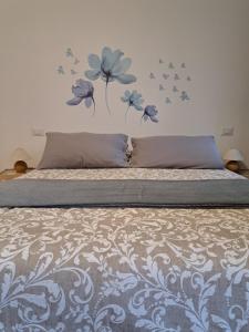 a bedroom with a bed with blue flowers on the wall at La casa di Noemi in Casale Corte Cerro