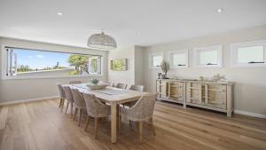 een keuken en eetkamer met een tafel en stoelen bij Sweeping Ocean Views From Killcare To Palm Beach in Killcare