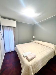 1 dormitorio con 1 cama grande y 2 toallas. en Hermoso, amplio y nuevo departamento, en la mejor ubicacion de la ciudad de Mendoza en Mendoza