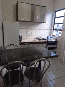 a kitchen with a table and chairs and a refrigerator at Reencanto Sonho Azul in Palhoça