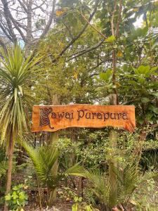 a sign in the middle of a garden with trees at Kawai Purapura Yoga Retreat Centre in Auckland