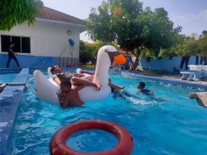 波德申的住宿－PD貝斯特度假屋，一群孩子在游泳池里,有一只充气鸭子