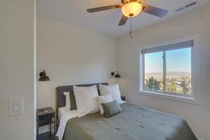 a bedroom with a bed with a ceiling fan and a window at Cedar City Home with Mountain Views and Game Room! in Cedar City