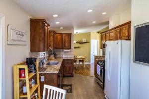 uma cozinha com armários de madeira e um frigorífico branco em The Dutch House Family Hideaway em Klamath Falls